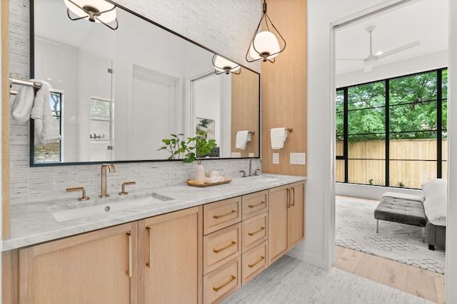 full bath featuring a sink, backsplash, and double vanity