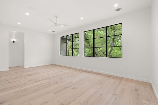 unfurnished room with visible vents, baseboards, light wood-type flooring, a ceiling fan, and recessed lighting