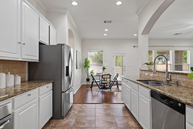 2529 Mirasol Loop, Round Rock, TX 78681 - kitchen with stainless steel appliances, a sink, healthy amount of natural light, tasteful backsplash, and ornamental molding