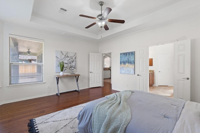 2529 Mirasol Loop, Round Rock, TX 78681 - bedroom featuring a tray ceiling, wood finished floors, crown molding, baseboards, and arched walkways
