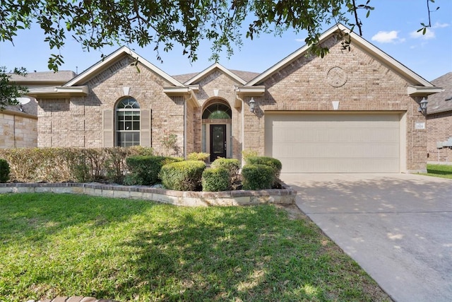 2529 Mirasol Loop, Round Rock, TX 78681 - view of front facade featuring a front yard, an attached garage, brick siding, and concrete driveway