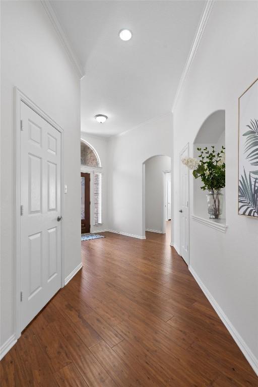 2529 Mirasol Loop, Round Rock, TX 78681 - empty room featuring arched walkways, ornamental molding, and wood finished floors