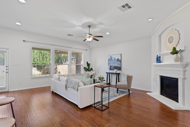 2529 Mirasol Loop, Round Rock, TX 78681 - living room with a ceiling fan, dark wood-style floors, a glass covered fireplace, ornamental molding, and recessed lighting