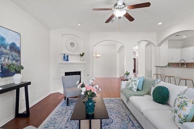 2529 Mirasol Loop, Round Rock, TX 78681 - living room featuring wood finished floors, ornamental molding, a ceiling fan, arched walkways, and baseboards