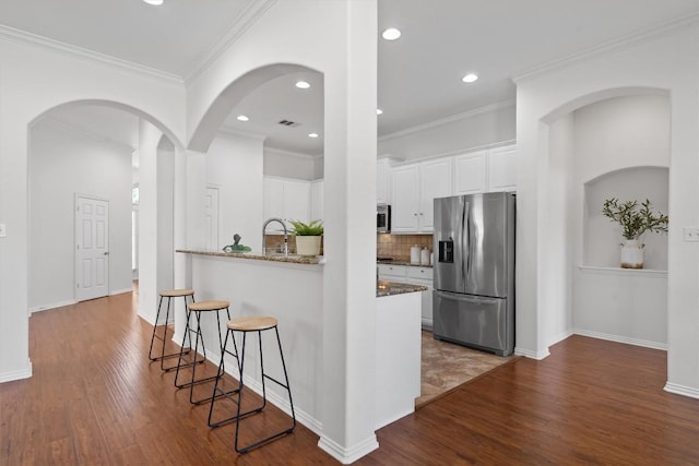2529 Mirasol Loop, Round Rock, TX 78681 - kitchen with appliances with stainless steel finishes, dark wood-style flooring, white cabinetry, tasteful backsplash, and recessed lighting