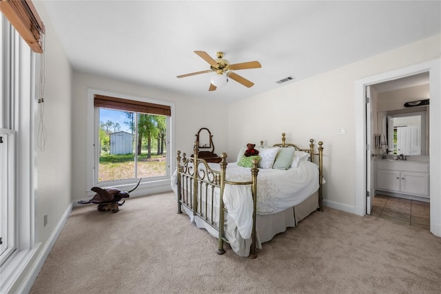 bedroom with baseboards, a ceiling fan, visible vents, light colored carpet, and a sink
