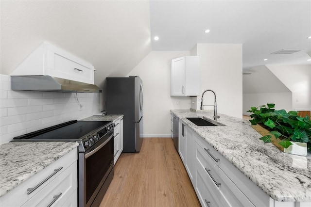 kitchen with white cabinetry, under cabinet range hood, light stone countertops, stainless steel appliances, and a sink