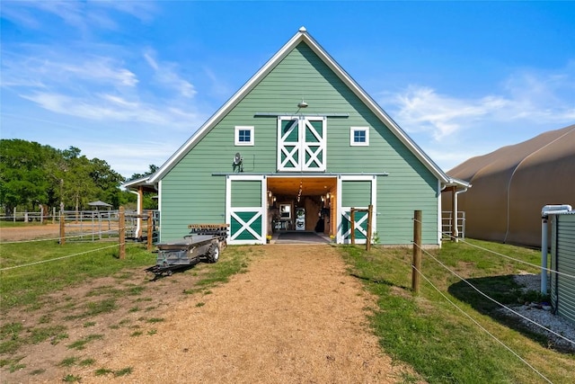 back of house featuring an outbuilding, fence, and an exterior structure