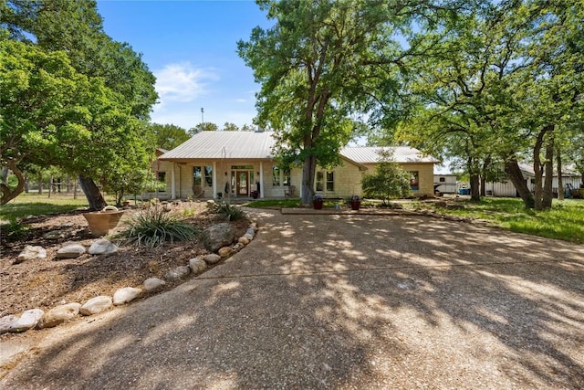 single story home featuring metal roof