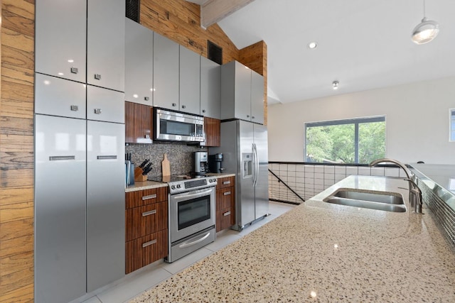 kitchen featuring vaulted ceiling with beams, a sink, light stone countertops, decorative backsplash, and appliances with stainless steel finishes