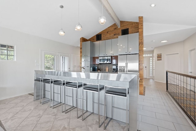 kitchen with stainless steel appliances, beam ceiling, baseboards, backsplash, and a breakfast bar area