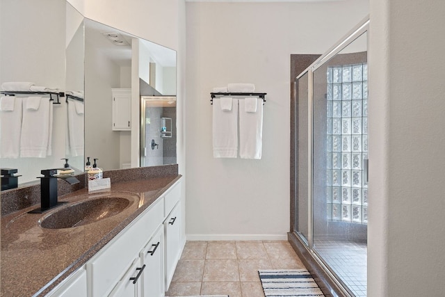 full bathroom featuring baseboards, vanity, tile patterned floors, and a stall shower