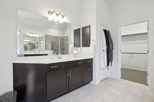 full bathroom featuring a shower stall, tile patterned floors, a spacious closet, vanity, and baseboards