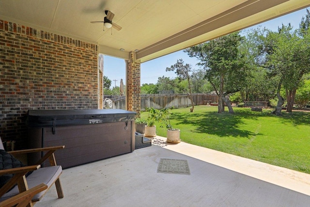 view of patio featuring a fenced backyard, a hot tub, and a ceiling fan