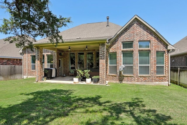 rear view of house featuring a fenced backyard, a yard, ceiling fan, a patio, and brick siding