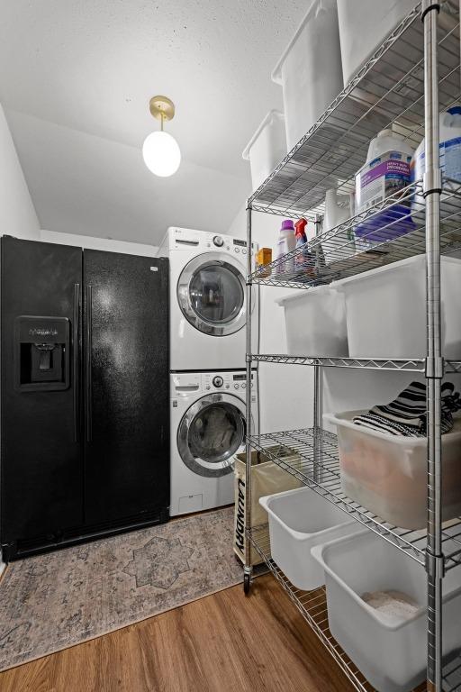 1403 E 16th St, Georgetown, TX 78626 - washroom featuring stacked washer / drying machine and wood finished floors