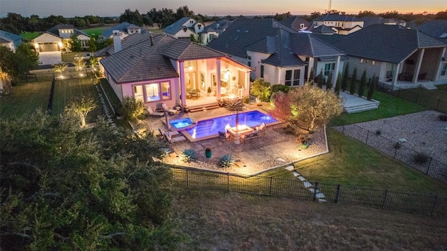325 E Cimarron Hills Trl, Georgetown, TX 78628 - back of property at dusk with stucco siding, a fire pit, a patio area, a residential view, and a chimney