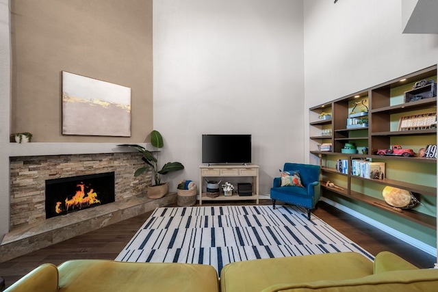 8200 Neely Dr Unit 217, Austin, TX 78759 - living area featuring a high ceiling, wood finished floors, a stone fireplace, and baseboards