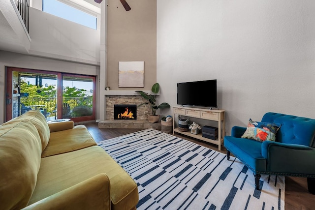 8200 Neely Dr Unit 217, Austin, TX 78759 - living room featuring wood finished floors, a ceiling fan, a stone fireplace, plenty of natural light, and a high ceiling
