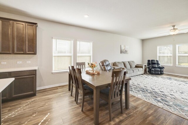 dining space with light wood-type flooring, plenty of natural light, and a ceiling fan