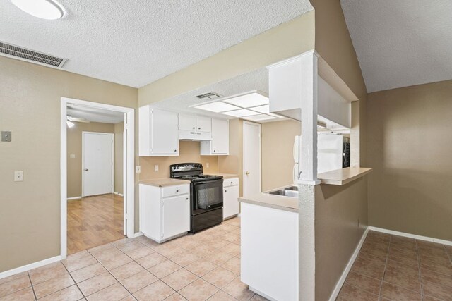 kitchen featuring light tile patterned floors, visible vents, black range with electric stovetop, and light countertops