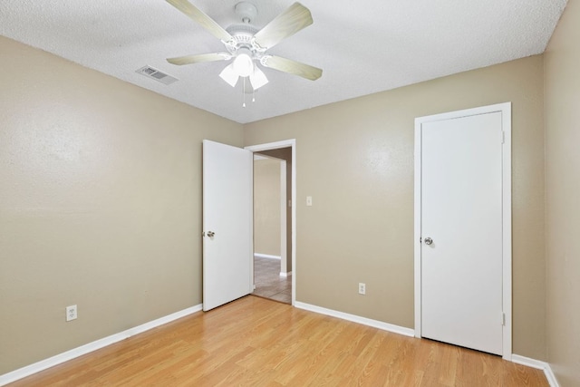 unfurnished bedroom featuring baseboards, a ceiling fan, visible vents, and light wood-type flooring