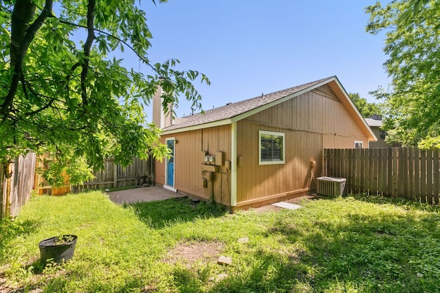 view of outdoor structure with central AC and a fenced backyard
