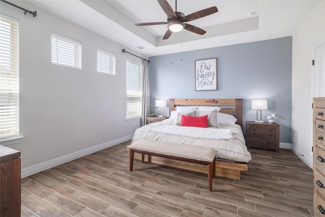 505 Saturnia Dr, Georgetown, TX 78628 - bedroom featuring a raised ceiling, wood finished floors, baseboards, and a ceiling fan