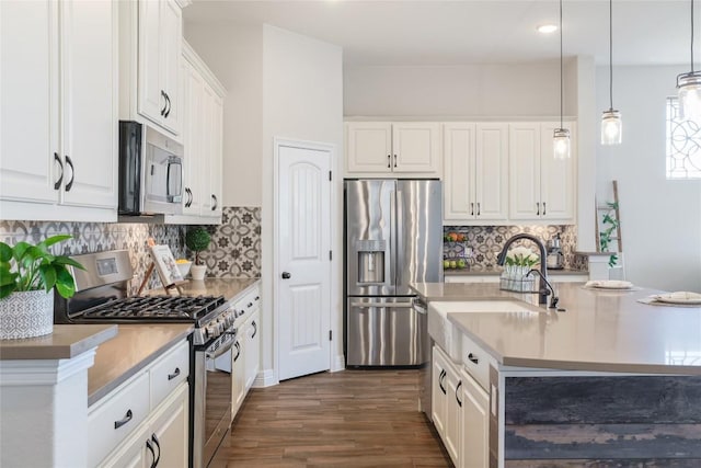 505 Saturnia Dr, Georgetown, TX 78628 - kitchen with stainless steel appliances, a sink, dark wood finished floors, white cabinetry, and backsplash