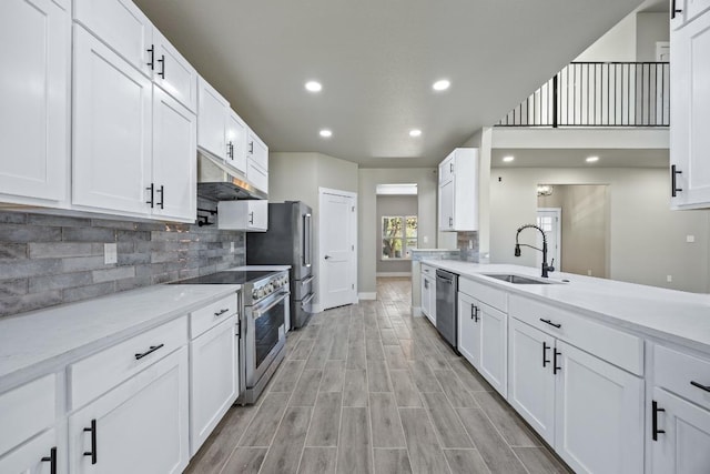 7 Harmony Ln, Wimberley, TX 78676 - kitchen featuring appliances with stainless steel finishes, under cabinet range hood, decorative backsplash, white cabinetry, and recessed lighting