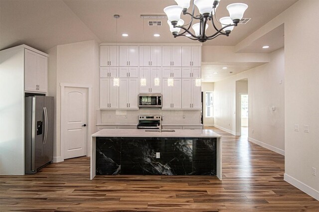 106 Passion Vine Rd, Dale, TX 78616 - kitchen featuring appliances with stainless steel finishes, a chandelier, white cabinets, dark wood-style flooring, and light countertops