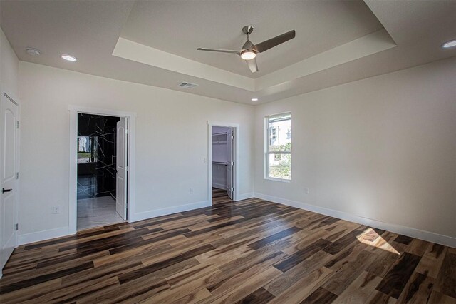 106 Passion Vine Rd, Dale, TX 78616 - unfurnished bedroom featuring a tray ceiling, a spacious closet, wood finished floors, a closet, and recessed lighting