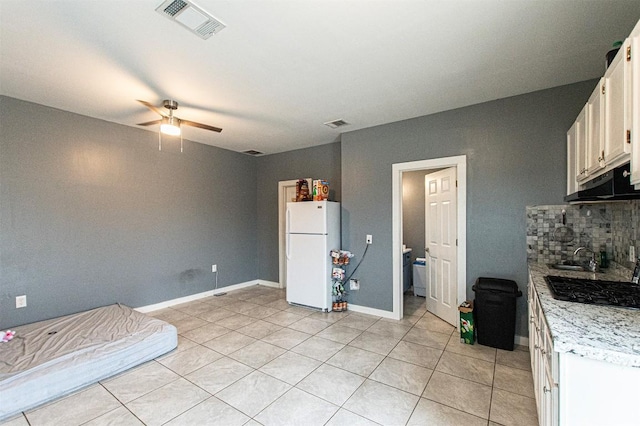 171 Milagros Dr, Cedar Creek, TX 78612 - kitchen with freestanding refrigerator, decorative backsplash, light tile patterned floors, light countertops, and a ceiling fan