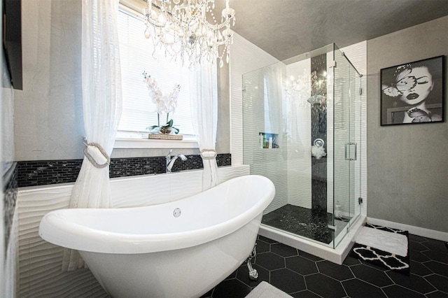 171 Milagros Dr, Cedar Creek, TX 78612 - bathroom with healthy amount of natural light, a freestanding tub, a chandelier, a shower stall, and tile walls