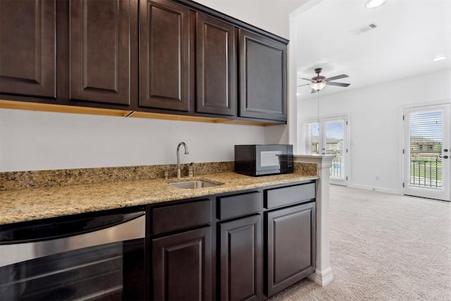 111 Antonio Way Unit 5A, Austin, TX 78734 - kitchen with beverage cooler, black microwave, light carpet, dark brown cabinets, and a ceiling fan