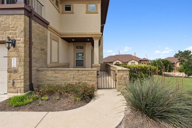 111 Antonio Way Unit 5A, Austin, TX 78734 - entrance to property with stucco siding, stone siding, and a gate