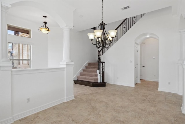 111 Antonio Way Unit 5A, Austin, TX 78734 - spare room with a chandelier, arched walkways, ornate columns, stairs, and a towering ceiling