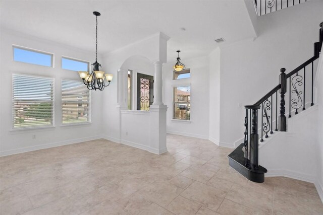 111 Antonio Way Unit 5A, Austin, TX 78734 - entryway featuring ornate columns, a chandelier, arched walkways, stairway, and light tile patterned floors