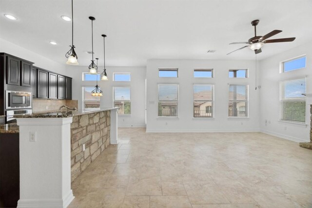 111 Antonio Way Unit 5A, Austin, TX 78734 - kitchen with appliances with stainless steel finishes, ceiling fan, dark stone counters, healthy amount of natural light, and recessed lighting
