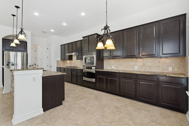 111 Antonio Way Unit 5A, Austin, TX 78734 - kitchen featuring appliances with stainless steel finishes, arched walkways, light stone countertops, backsplash, and recessed lighting
