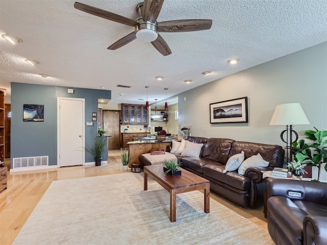 822 Hermitage Dr, Austin, TX 78753 - living room with a textured ceiling, a ceiling fan, light wood finished floors, and recessed lighting