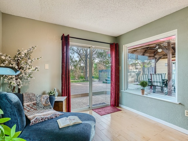 822 Hermitage Dr, Austin, TX 78753 - living area with a textured wall, a textured ceiling, wood finished floors, and baseboards