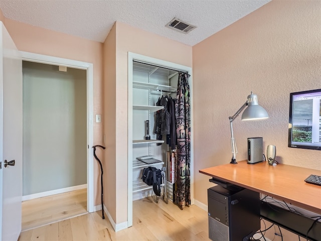 822 Hermitage Dr, Austin, TX 78753 - home office featuring wood finished floors, a textured wall, a textured ceiling, and baseboards