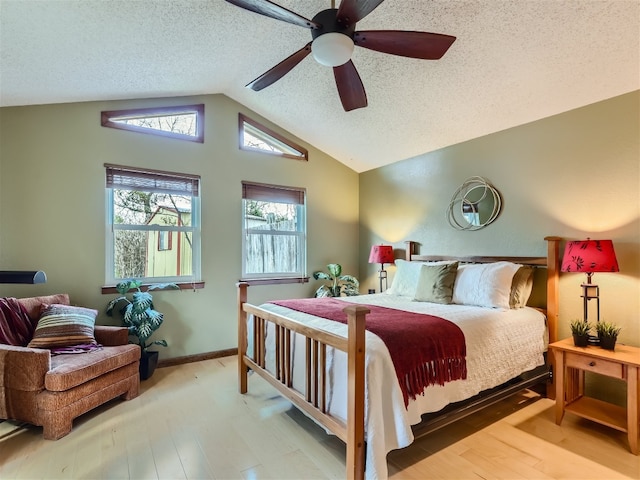 822 Hermitage Dr, Austin, TX 78753 - bedroom with lofted ceiling, wood finished floors, a ceiling fan, and a textured ceiling