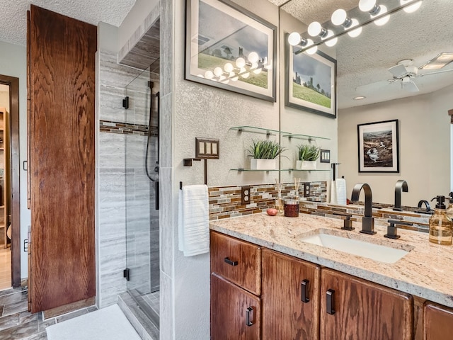 822 Hermitage Dr, Austin, TX 78753 - full bathroom with a textured ceiling, a shower stall, a ceiling fan, vanity, and tasteful backsplash