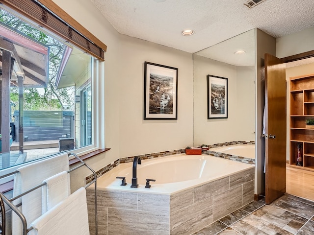 822 Hermitage Dr, Austin, TX 78753 - full bath featuring a bath, a textured ceiling, and recessed lighting