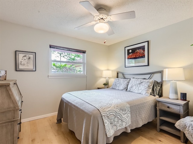 822 Hermitage Dr, Austin, TX 78753 - bedroom featuring light wood finished floors, baseboards, a ceiling fan, and a textured ceiling