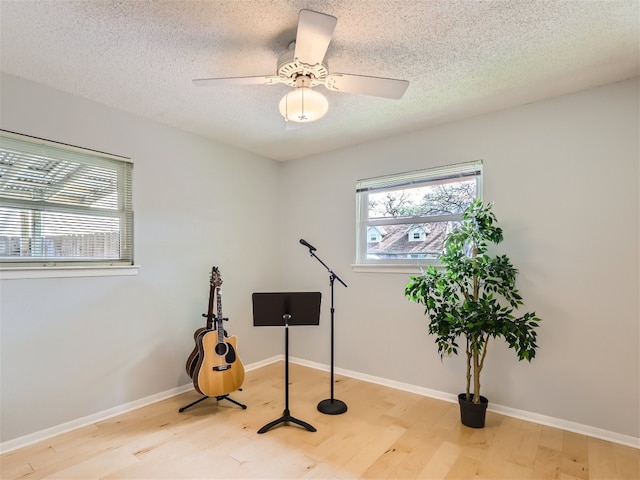 822 Hermitage Dr, Austin, TX 78753 - exercise room with wood finished floors, a textured ceiling, baseboards, and ceiling fan