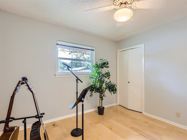 822 Hermitage Dr, Austin, TX 78753 - exercise area with light wood-style floors, a ceiling fan, and a textured ceiling