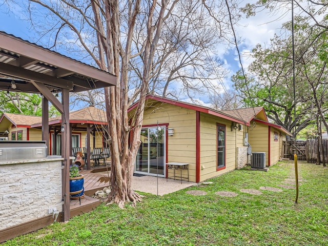 822 Hermitage Dr, Austin, TX 78753 - rear view of house with cooling unit, a wooden deck, a shingled roof, a patio, and an outdoor kitchen